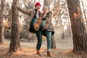 Traveler couple show boots and having fun in highlands. Freedom and active lifestyle concept.