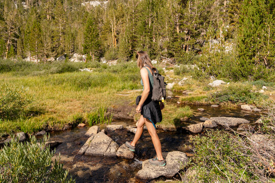 hiking crossing river rocks