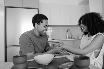 Candid moment: couple laughing and holding hands in kitchen