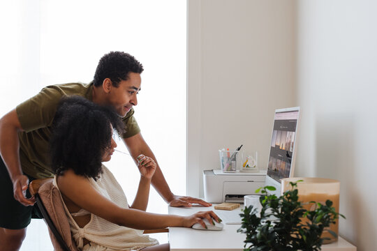 Couple working together at home office with computer