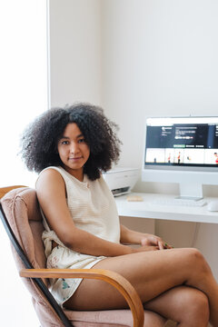 Candid woman at home office with computer monitor and relaxed mo