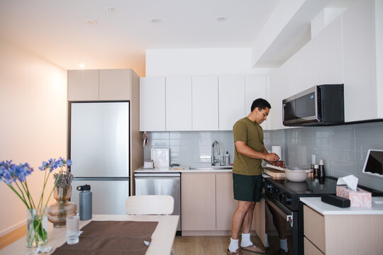Candid kitchen moment: man cooking at home in modern kitchen
