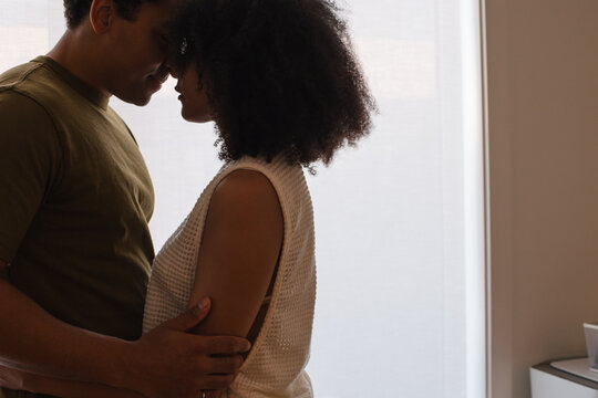Candid couple in embrace, close and intimate moment at home