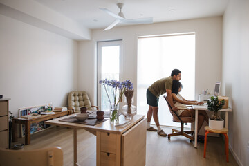 Candid family moment at home with couple at computer