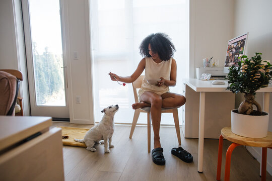 Candid moment of a woman with her dog during a home office routi