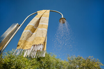 Outdoor Beach Shower with Flowing Water and Hanging Towel