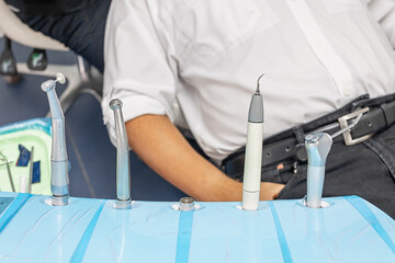 Close-up of professional dental instruments arranged on a blue tray in a modern clinic. Concept of...