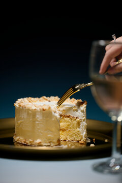Delicious cake slice with a fork and a glass of wine