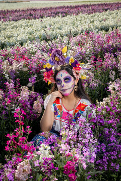 Mexican catrina posing gracefully in the middle of a field of lilies