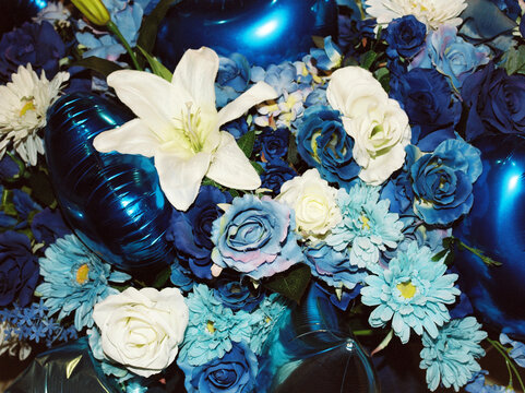 A bouquet of blue and white flowers and balloons