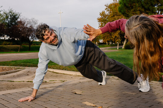 Elderly man sharing holistic outdoor wellness workout with his partner