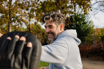 Man practices martial arts with supervision of geriatric specialist