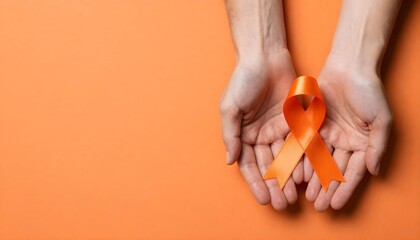 An orange ribbon held in hands on an orange background, representing ADHD awareness and mental health advocacy