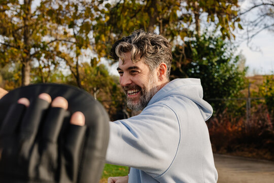 Man practices martial arts with supervision of geriatric specialist
