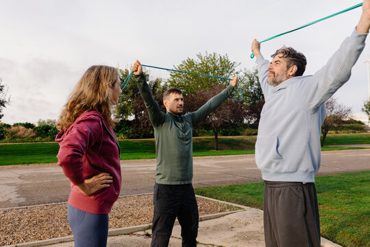 Coach encourages an elderly couple as they complete strength training