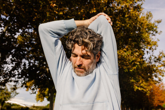 Mature man stretching his arms as part of a pre-exercise warm-up