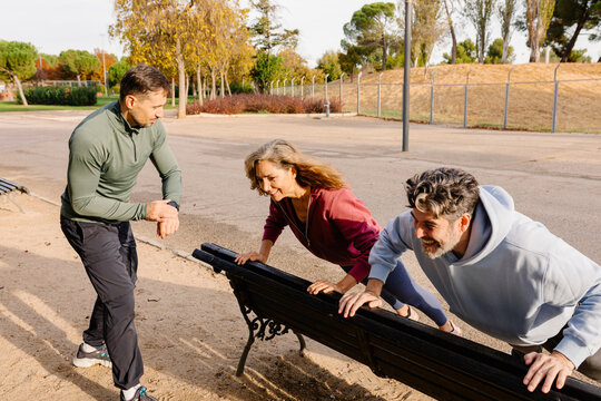 Elderly couple performing strength workout with a geriatric trainer