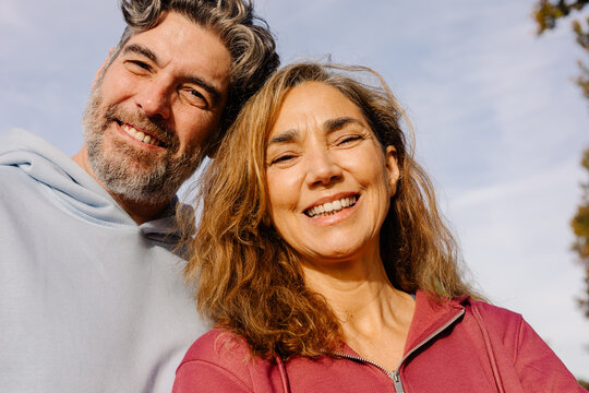 Close-up selfie of a middle-aged couple grinning at the camera