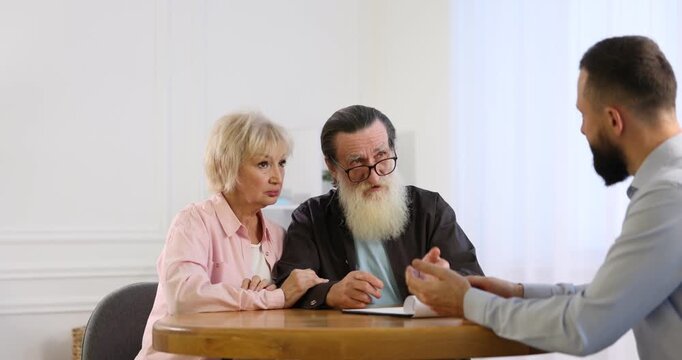 Notary consulting senior couple about Last Will and Testament in office