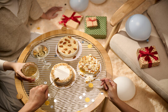 Celebration with cake, gifts, and drinks on a round table from above
