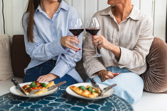 Close-up of Mother and Daughter Eating Pizza and Drinking Wine