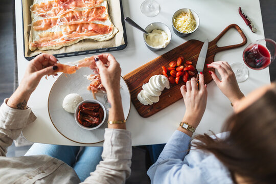 Overhead View of Family Preparing Homemade Pizza
