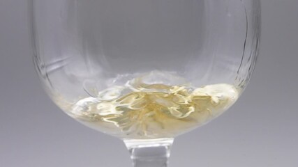 SLOW MOTION CLOSE UP SHOT OF RUM BEING POUR ON A GLASS CUP