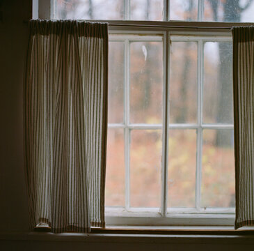 Cabin window with curtains in the fall