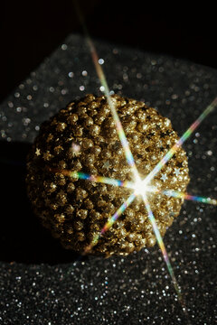 Shiny Golden Ball on Sparkling Surface With Bright Star Effect