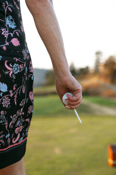 Close up of hand holding a white swab outdoors in a sunny park