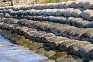 Stacked sandbags installed along the shoreline at Portsea Beach in Victoria, Australia, forming a...