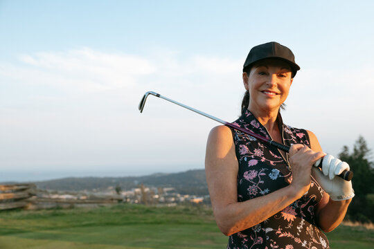 Candid smiling woman golfer on a sunny outdoor golf course