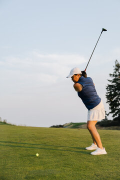 Candid golfer in motion: focused swing on sunny golf course
