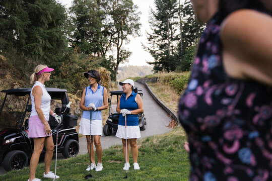 Candid moment of female golfers chatting on the golf course
