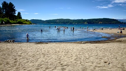 gente disfrutando en un lago con fondo de montañas