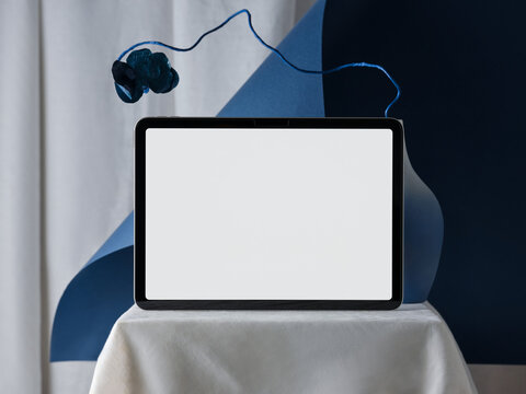 tablet with blank screen on a table with abstract blue background