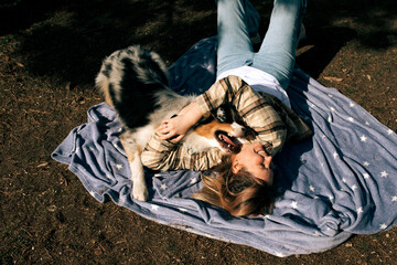 Middle-aged woman with her pet dog in the autumn forest.
