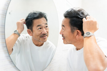 Obraz premium ヘアチェックをするミドル男性 ビューティーイメージ