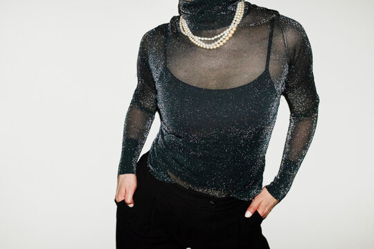 Person wearing party glitter shirt and shiny pearl necklaces in party