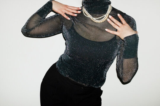 Person wearing party glitter shirt and shiny pearl necklaces in party