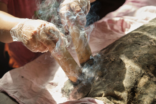 Closeup of the hand holding the moxa stick during treatment