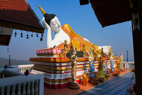 Magnificent giant reclining Buddha statue at Wat Phra That Doi Kham temple on the mountain side of Chiang Mai, Northern Thailand