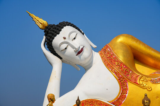 Magnificent giant reclining Buddha statue at Wat Phra That Doi Kham temple on the mountain side of Chiang Mai, Northern Thailand