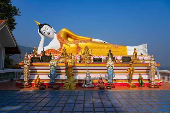 Magnificent giant reclining Buddha statue at Wat Phra That Doi Kham temple on the mountain side of Chiang Mai, Northern Thailand