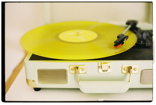 Yellow Vinyl Record Spins on Vintage Turntable in Cozy Setting