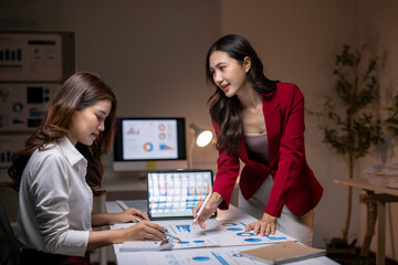 Businesswomen collaborating on financial data analysis in office
