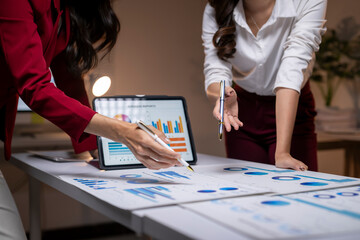 Businesswomen analyzing data, charts, graphs on tablet
