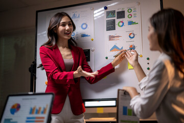 Businesswoman giving presentation analyzing data to colleague