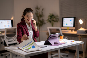 Asian businesswoman working late managing corporate budget
