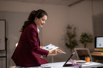 Businesswoman analyzing data late in a modern office